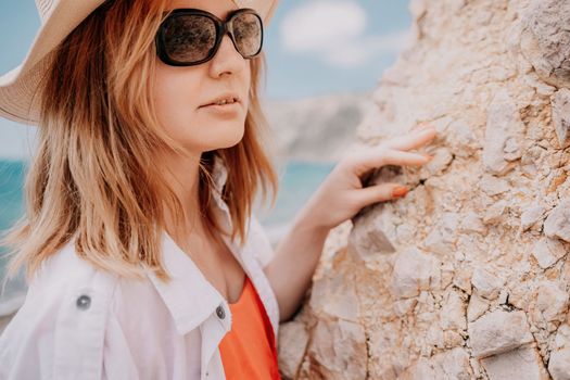 Young woman in red bikini on Beach. Blonde in sunglasses on pebble beach enjoying sun. Happy lady in one piece red swimsuit relaxing and sunbathing by turquoise sea ocean on hot summer day. Close up,