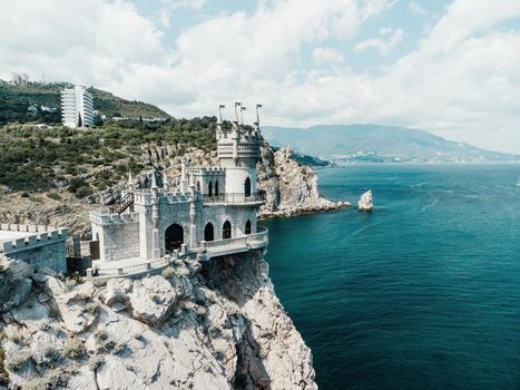 Aerial view of Swallow's Nest castle on the rock in Black Sea. It is a symbol and landmark of Crimea. Beautiful scenic panorama of the Crimea coast. Amazing Swallow's Nest at the precipice.