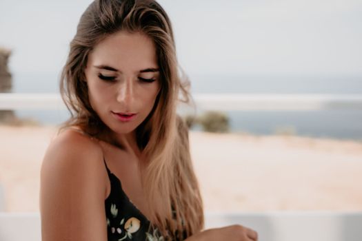 Happy woman portrait in cafe. Boho chic fashion style. Outdoor photo of young happy woman with long hair, sunny weather outdoors sitting in modern cafe