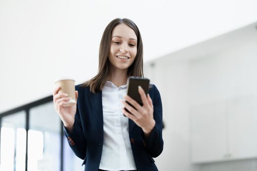 Excited businesswoman using mobile phone while in office , business concepts