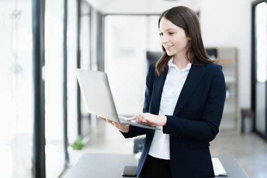Excited businesswoman using computer laptop while in office, business concepts