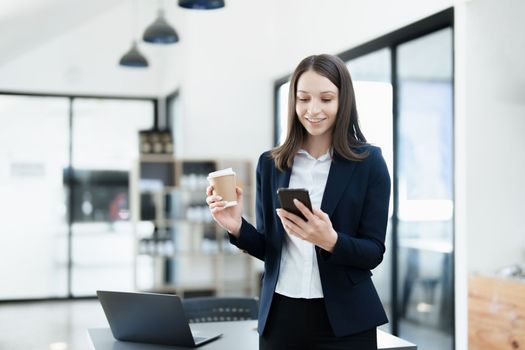 Excited businesswoman using mobile phone while in office , business concepts