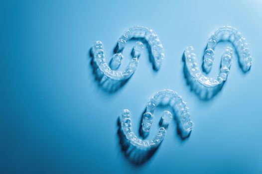 plastic braces in the shape of a pattern lie on a blue background, dental care and health.