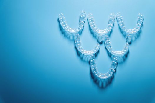 transparent straighteners for teeth in the shape of a pyramid on a blue background, dentistry and orthodontics. 3D printing in modern medicine.