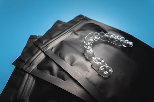 corrective aligners for the beauty of teeth lie on a black package. special storage bags. dentistry and health care.