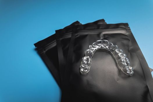 corrective aligners for the beauty of teeth lie on a black package. special storage bags. dentistry and health care.