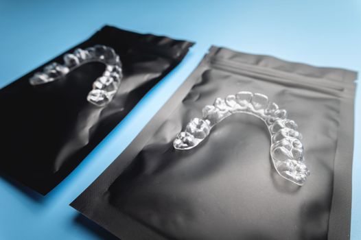 corrective aligners for the beauty of teeth lie on a black package. special storage bags. dentistry and health care.