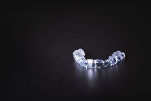 layout for orthodontics banner. transparent plastic aligners on black background.