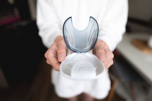 transparent braces in female hands close-up in a special orthodontic container.