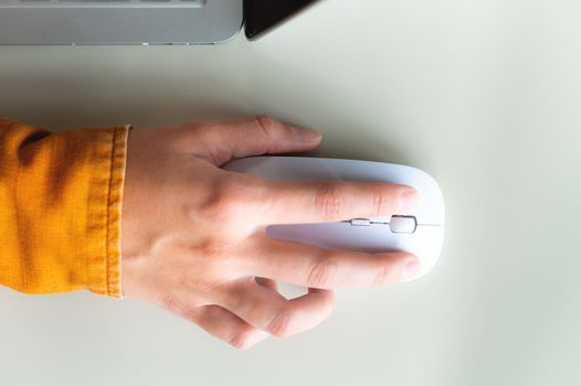 Close-up woman searching and clicking mouse using laptop, online shopping concept. Blurred background, vertical shot