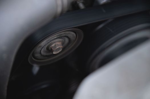 Worn old car engine alternator belt tensioner, close-up.