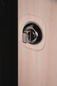 Close up of stylish silver chrome door handle on modern interior door. Stylish light brown door with frosted glass inserts. Concept of catalog of door handles for furniture store.