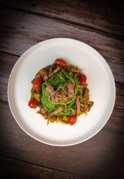 Recipe for spaghetti with spinach cream and smoked bacon, tomatoes and chanterelle mushrooms. High quality photo