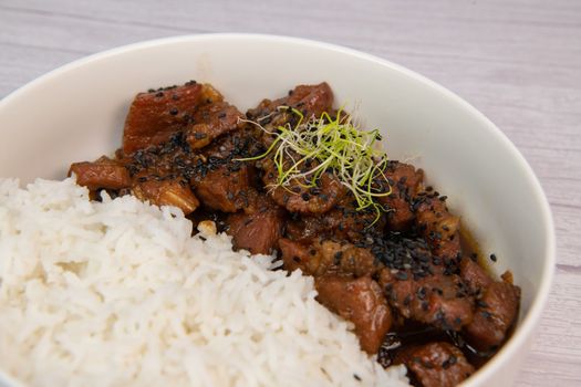 Caramel pork recipe with rice and black sesame seeds. High quality photo