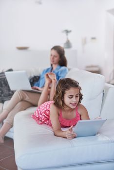 Theyre never short of entertainment. a mother and her daughter using wireless technology at home