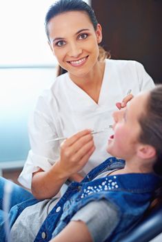 Your childs hygiene is my priority. a female dentist and child in a dentist office