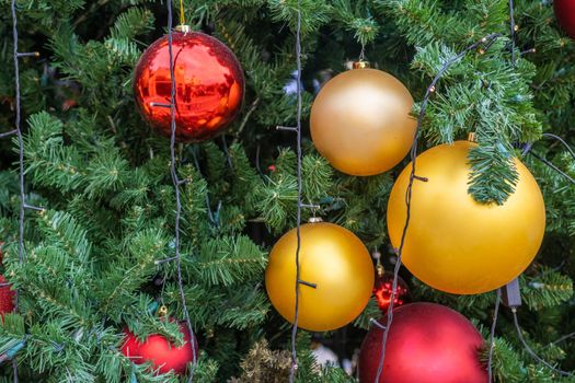 Smartly decorated Christmas tree branches in daylight.