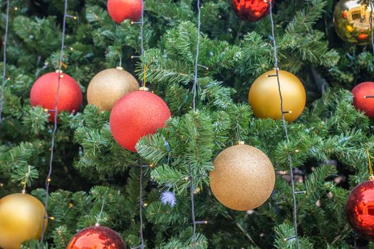 Smartly decorated Christmas tree branches in daylight.