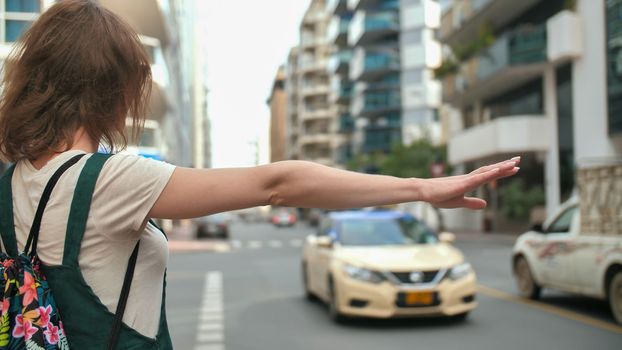 The girl stops a taxi in Dubai