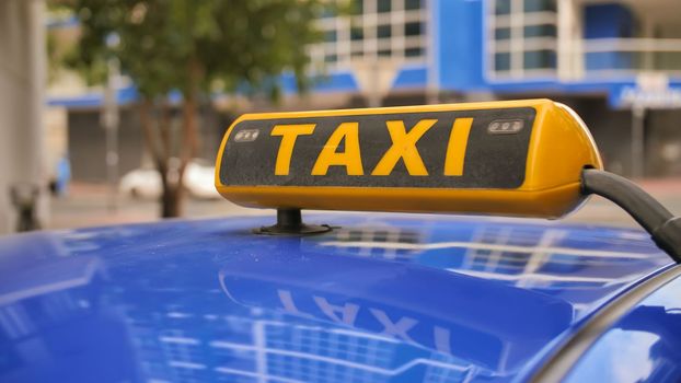 Yellow taxi sign on a car roof. Dubai Taxi