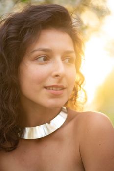 Portrait of a young sexy brunette girl with a necklace around her neck.