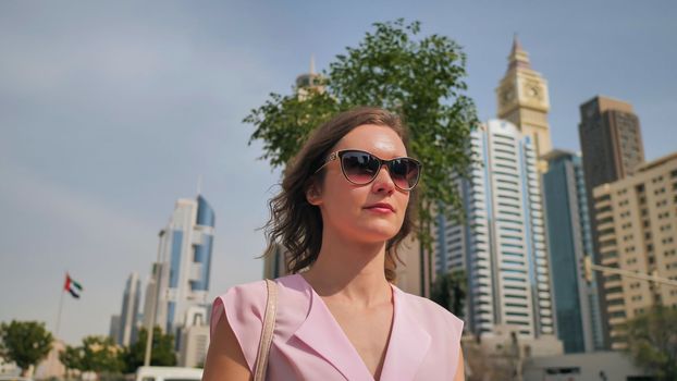 A beautiful young woman is walking in the center of Dubai