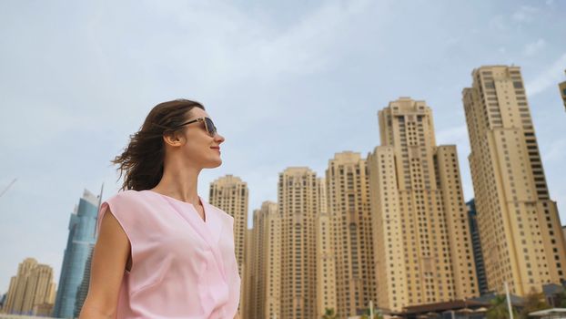 A beautiful young woman is walking in the center of Dubai