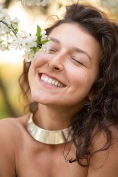 Portrait of a young laughing sexy brunette girl with a necklace around her neck.