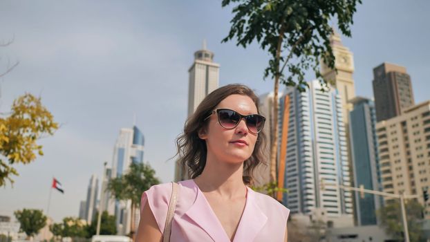A beautiful young woman is walking in the center of Dubai