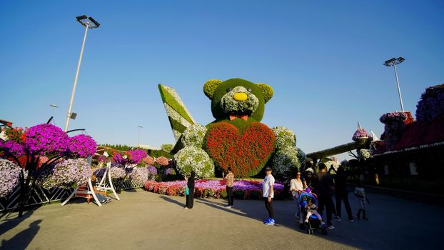 Teddy bear holds a big heart in his hands. Dubai Miracle Garden in the UAE. It has over 45 million flowers