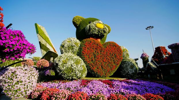 Teddy bear holds a big heart in his hands. Dubai Miracle Garden in the UAE. It has over 45 million flowers