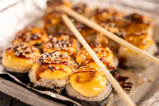 Sushi rolls in a thermal box are ready for delivery to the customer. Japanese sushi takeaway. Sushi rolls in a plastic thermo container. Takeaway food. Japanese food at home. top side view