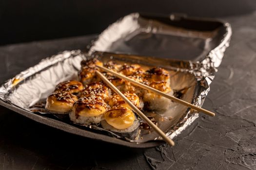 Sushi rolls in a thermal box are ready for delivery to the customer. Japanese sushi takeaway. Sushi rolls in a plastic thermo container. Takeaway food. Japanese food at home. top side view