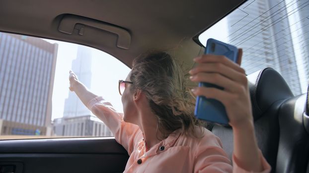 The girl is broadcasting live from a car using a phone from Dubai