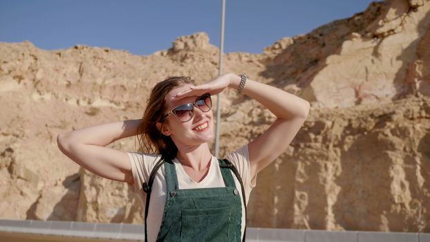 Happy girl posing against the backdrop of the mountains of Al Ain city. United Arab Emirates