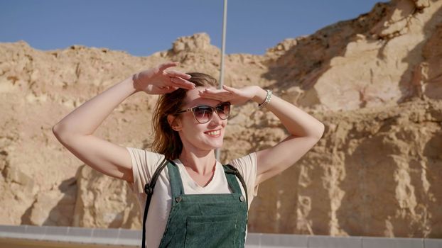 Happy girl posing against the backdrop of the mountains of Al Ain city. United Arab Emirates