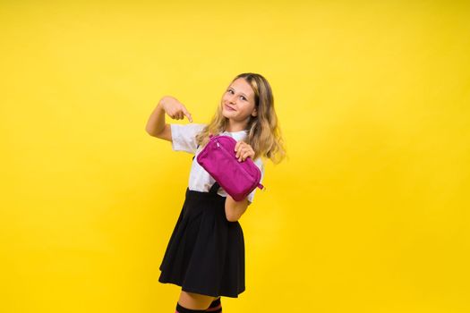 Happy schoolgirl with colored pencils and pencil case in hand