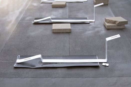 Brackets for installing solar panels on the roof of a building. Aluminum fixtures for solar modules are placed on the roof before the panels are installed
