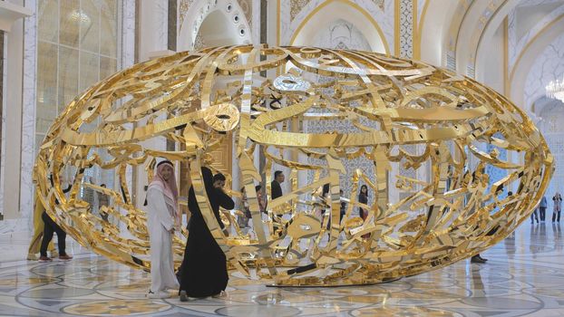 People walking near sculptural composition the power of words in Presidential Palace, Palace of Qasr al-Watan the Palace of the nation in Abu Dhabi