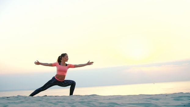 Healthy, young beautiful woman meditating, practicing yoga on the sea beach, at sunrise, Makes exercises for balance and coordination, deep muscle tone. close up. High quality photo