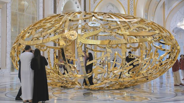 People walking near sculptural composition the power of words in Presidential Palace, Palace of Qasr al-Watan the Palace of the nation in Abu Dhabi