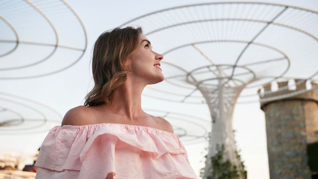 Girl on the background futuristic metal flowers in Dubai Miracle Garden Park