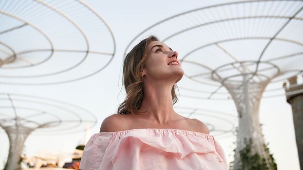 Girl on the background futuristic metal flowers in Dubai Miracle Garden Park