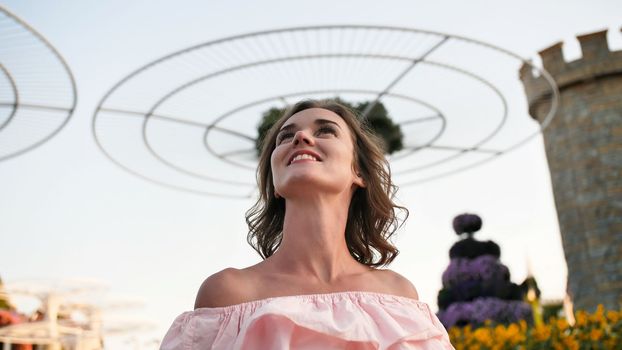 Girl on the background futuristic metal flowers in Dubai Miracle Garden Park