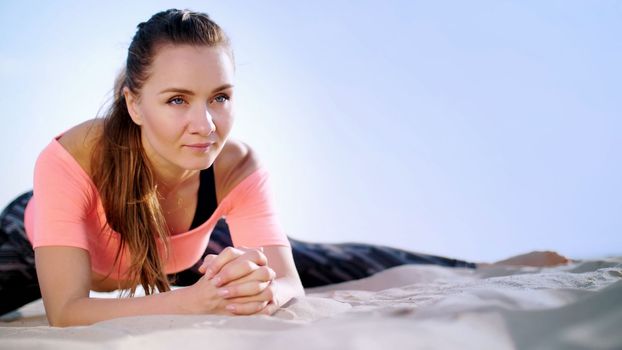 Healthy, young beautiful woman stretching, practicing yoga on the beach, at sunrise, Makes exercises for balance and coordination, deep muscle tone. relaxation of muscles, mind. High quality photo