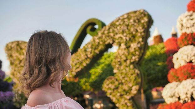 A girl walks through a beautiful fairytale park in Dubai