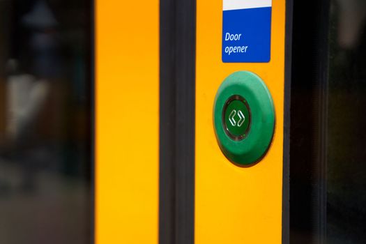 A close-up of an external button for opening doors in a tram.