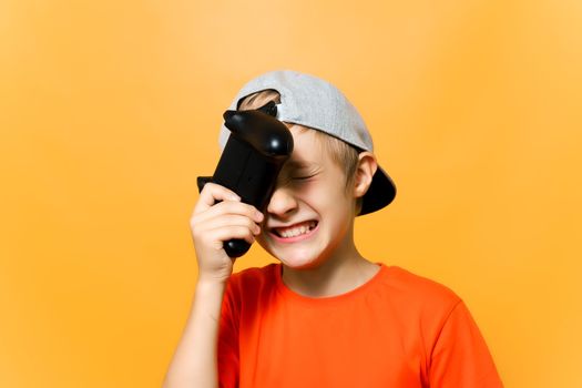 the computer gamer boy leaned the gamepad against his head and grimaced he was disappointed with losing the game