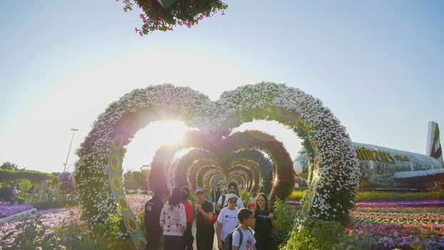 Heart shaped flower beds at the Alley of Hearts. Dubai Miracle Garden is famous for its extraordinary flower installations. A couple of people walking around at the park.