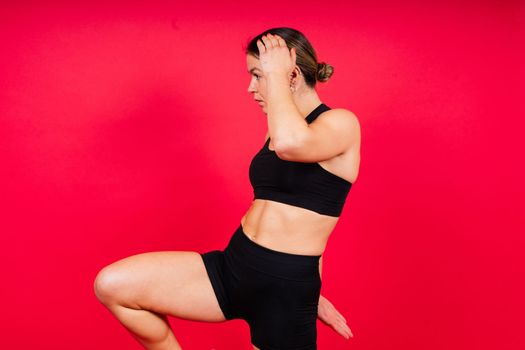 Strong sportswoman in boxing gloves prepared high kick. Isolated on a white, red, yellow background